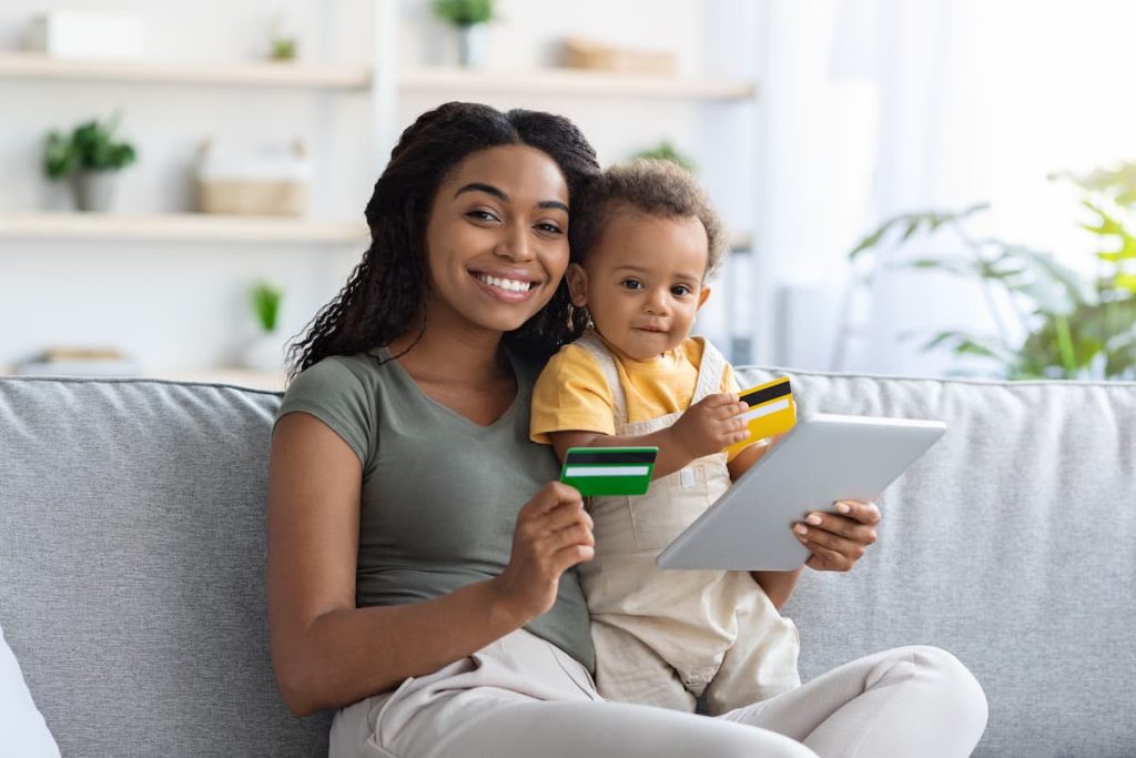 Black mom with child using online payments.
